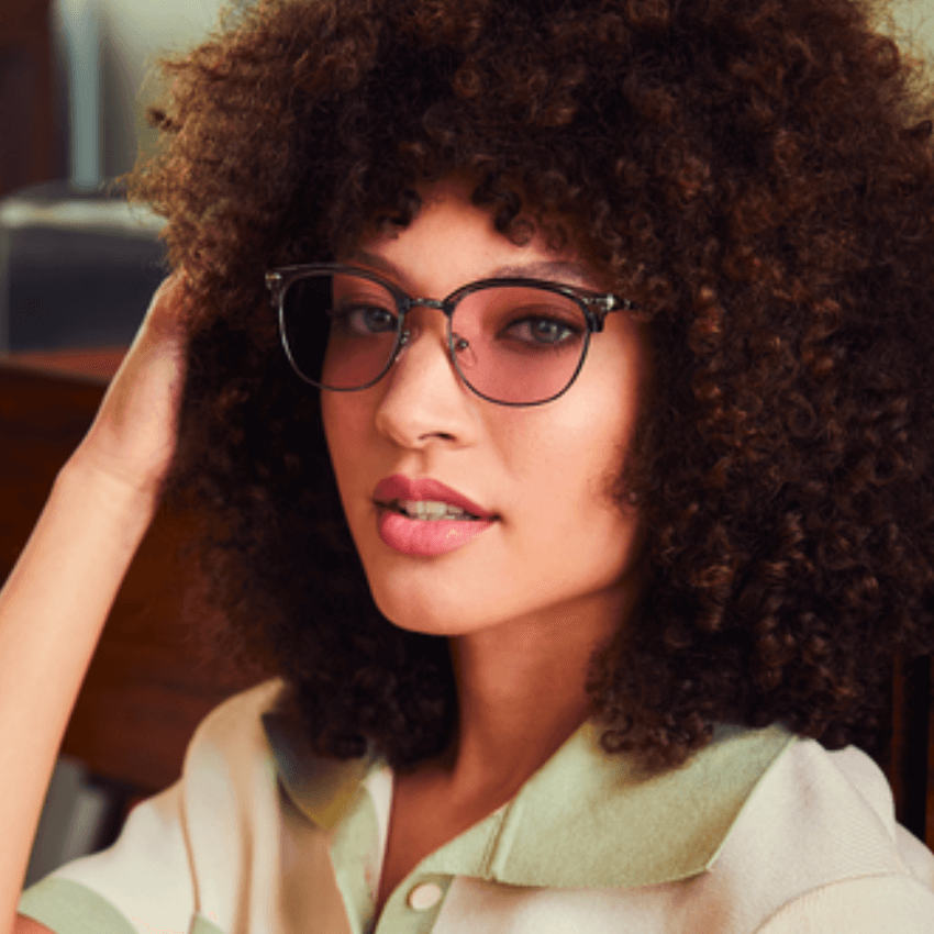 Woman wearing stylish transparent eyeglasses with a slender metal frame.