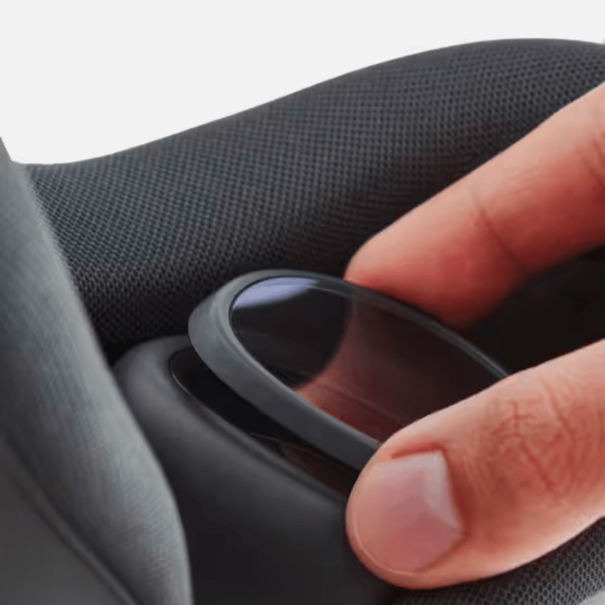 Hand adjusting a black circular lens insert on a textured seat cushion.