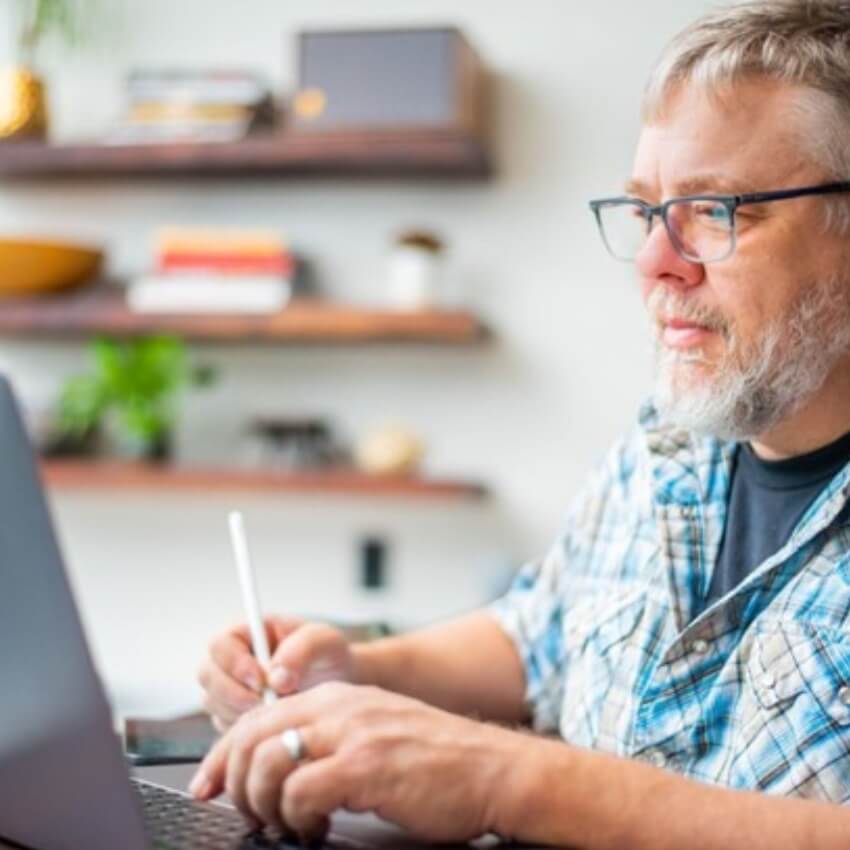 Man using a stylus on a laptop.