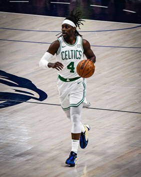 Basketball player in white uniform with green text "CELTICS 4" dribbling the ball on a court.